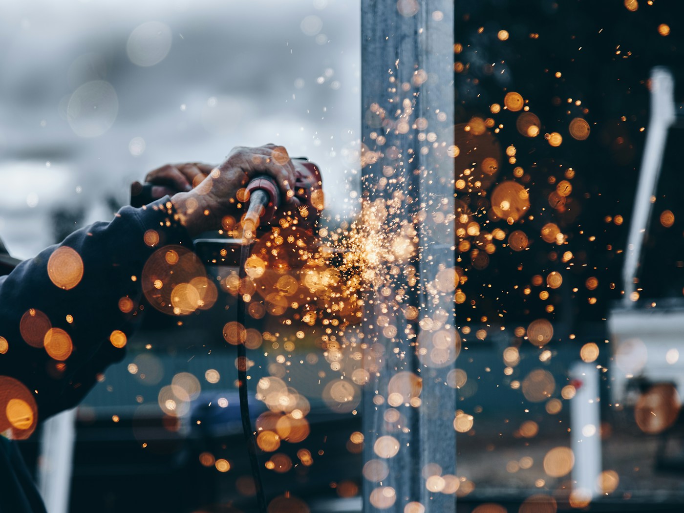A skilled contractor working with metal and visible sparks