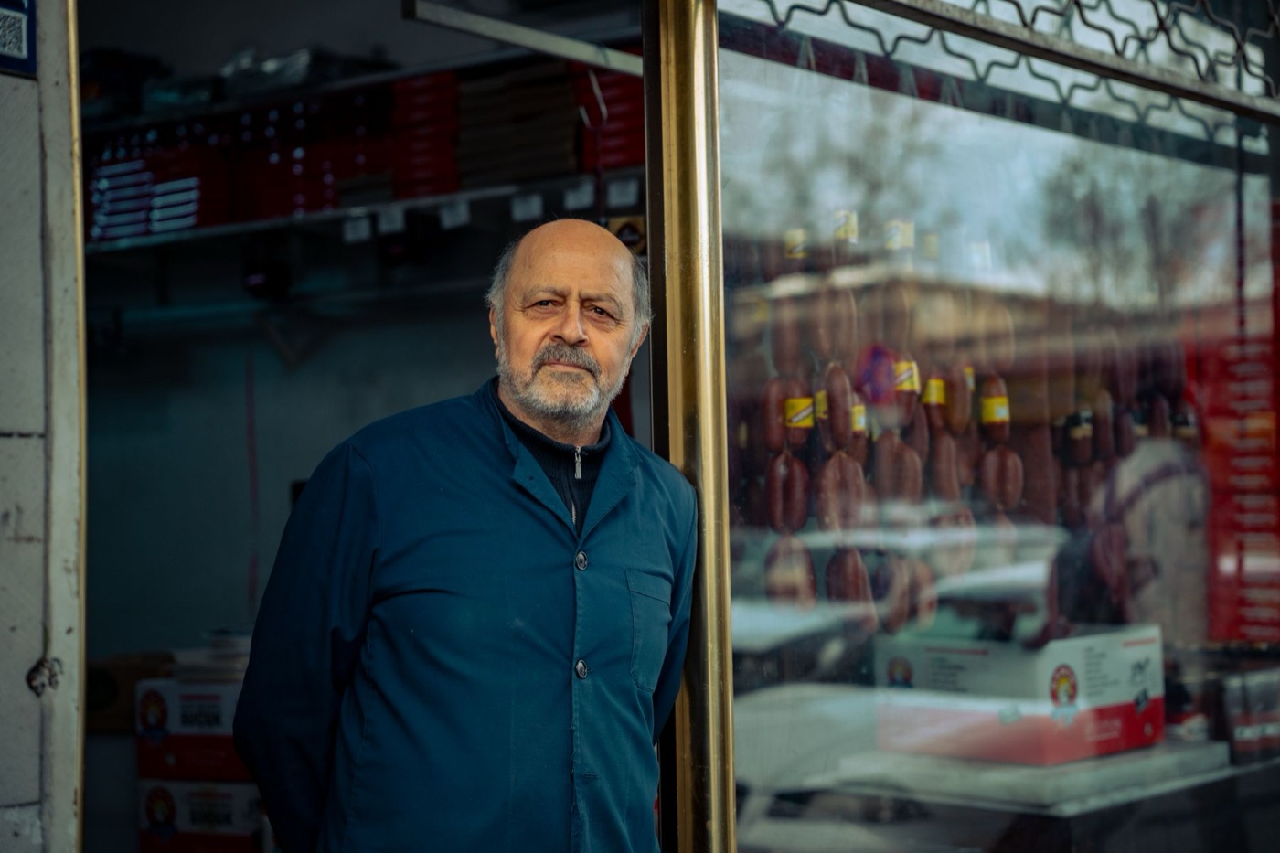 An independent shop owner standing at the entrance of his local store