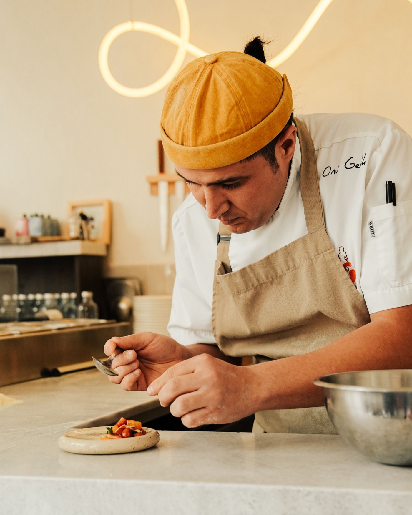 A chef carefully plating a dish in a professional restaurant kitchen